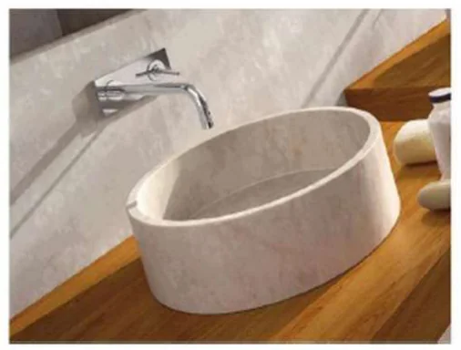 Photo d'une vasque cylindrique en pierre claire posée sur un plan de toilette en bois, sous un robinet mural