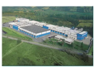 Vue aérienne d’une usine Photo aérienne d’une usine aux toits bleus et gris entourée de verdure — exercice de maths en 4ème sur les fractions et les proportions