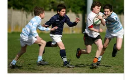 Joueurs de rugby du collège Jeunes joueurs de rugby du collège en plein match, l’un courant avec le ballon — exercice de maths en 6ème sur la division euclidienne et décimale sur les équipes
