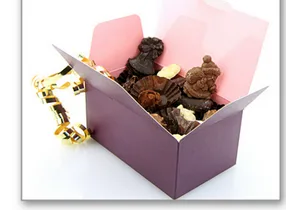 Ballotin ouvert de chocolats Ballotin rose et violet ouvert rempli de chocolats variés — exercice de maths en 6ème sur la division euclidienne et décimale sur les ballotins de chocolat