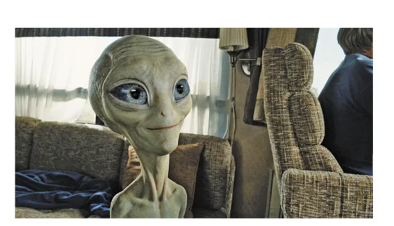 Alien Paul dans un salon Extraterrestre gris aux grands yeux bleus assis dans un salon, illustration d’un sondage — exercice de maths en 2de sur l’intervalle de confiance